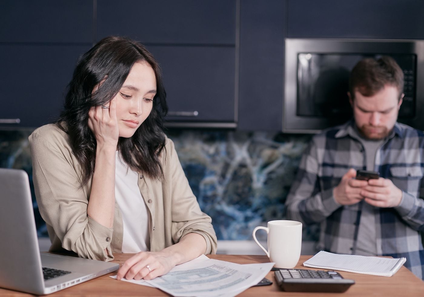Couple experiencing stress while managing household finances at home.